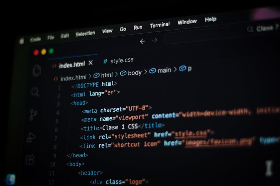 Close-up view of a computer screen displaying colorful lines of HTML code, with syntax highlighting in red, green, blue, and purple on a black background. The code includes various tags, attributes, a
